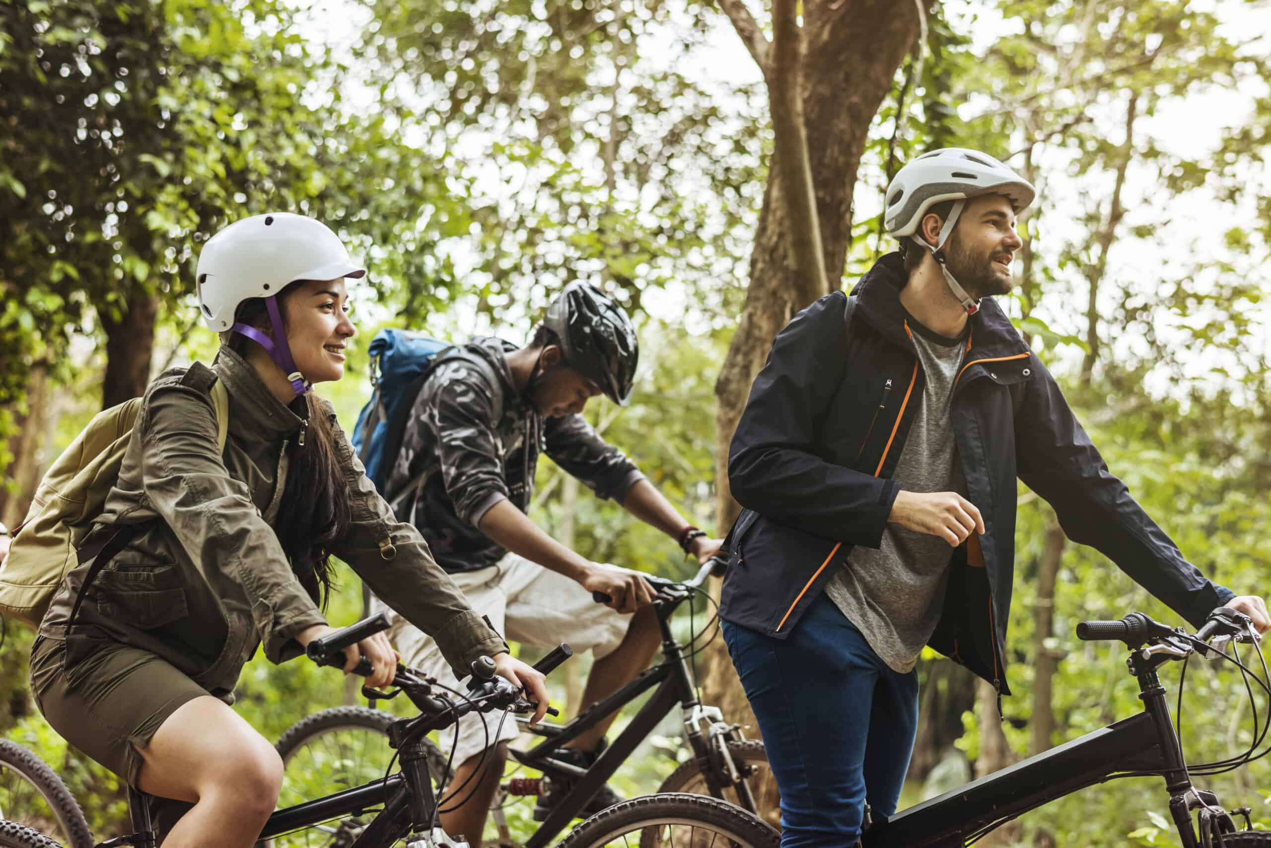 Group of friends ride mountain bike in the forest together